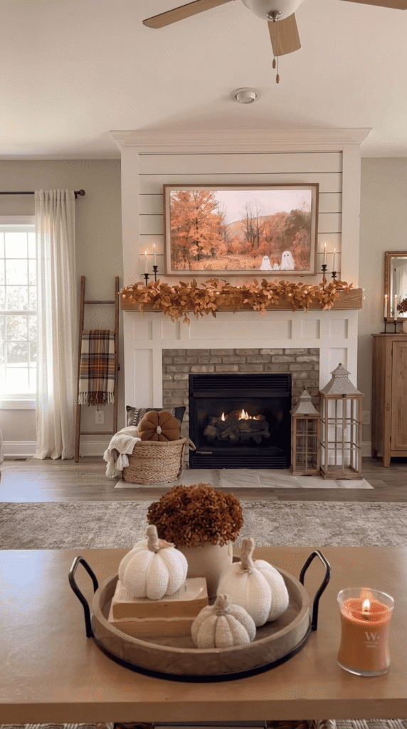 Fall-styled fireplace mantel with candles and garland in a living room