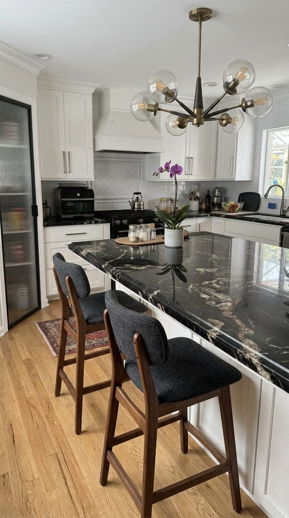Black kitchen island with a white quartz top in an all-white kitchen