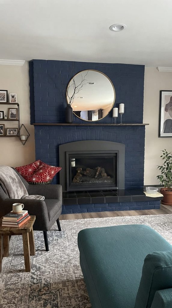 Minimal mantel with one tall branch in a vase and two candles